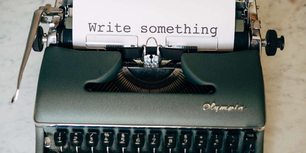 green typewriter with the words write something on